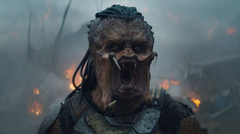 An alien Yautja screaming in the middle of a burning forest in Predator: Badlands