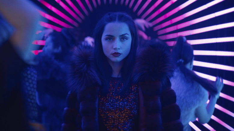 Eve walks through a neon-lit club in Ballerina