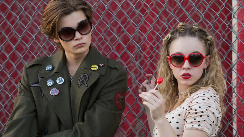Oliver Schmerhorn and Emaline Addario standing against the fence in Everything Sucks!