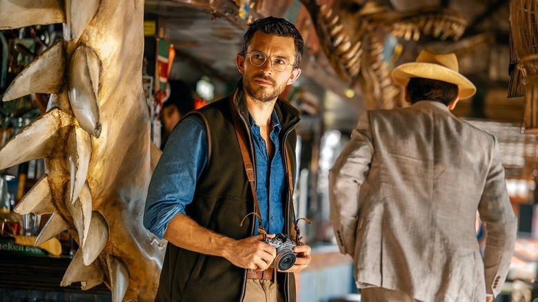 Jonathan Bailey as Dr. Henry Loomis holding a camera in Jurassic World Rebirth