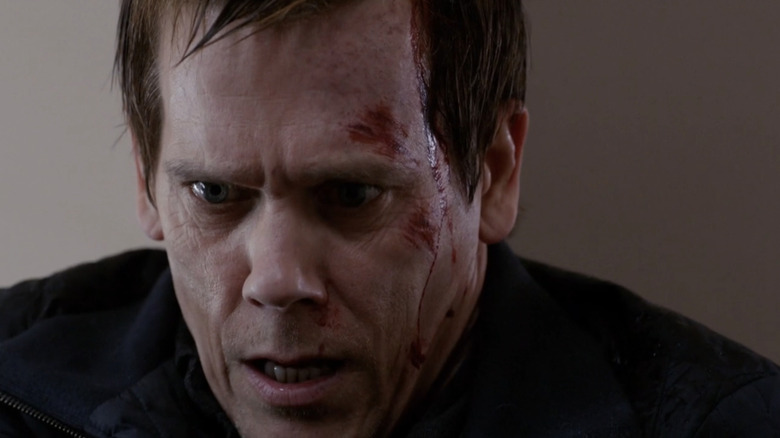 Kevin Bacon's Ryan Hardy looks down with blood dripping down his face in The Following