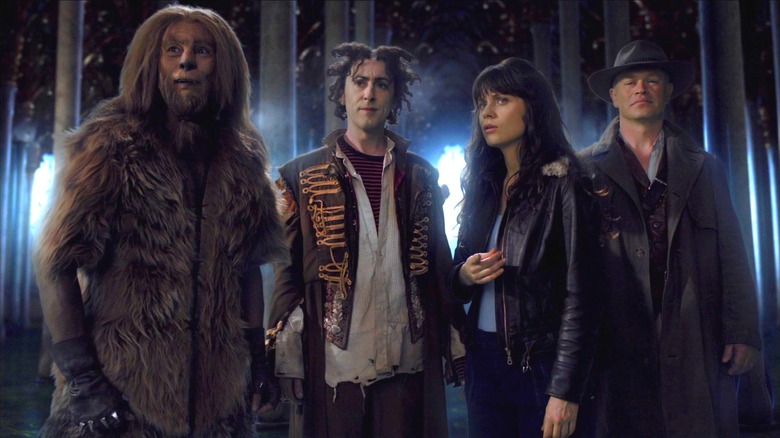 Raoul Trujillo as Raw, Alam Cumming as Glitch, Zooey Deschanel as DG, and Neal McDonough as the Tin Man standing together and looking concerned in Tin Man